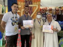 The Diocesan Vocation Director hands over the Certificate of Participation to the Rogationists and the Daughters of Divine Zeal for their joint vocation exhibit booth.