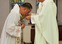 Fr. Masilang receiving the missionary cross from Fr. Tecson
